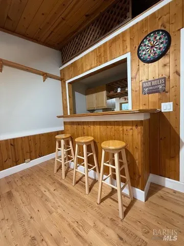 a kitchen with stainless steel appliances kitchen island granite countertop a table chairs and a wooden floor