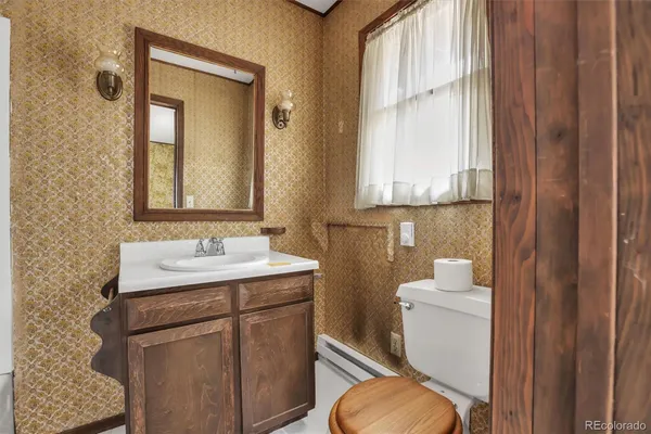 a bathroom with a toilet sink and mirror