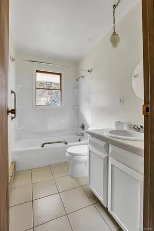 a bathroom with a granite countertop sink a toilet and bathtub