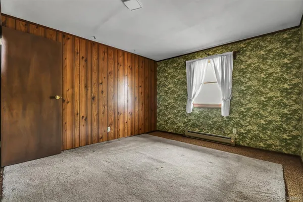 a view of an empty room with a window and a door