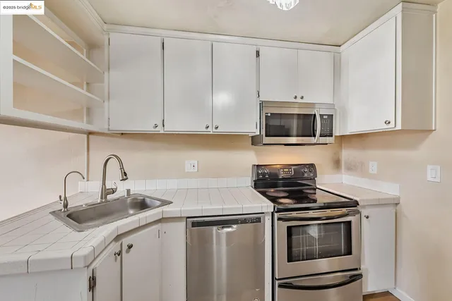 a kitchen with appliances a sink and cabinets