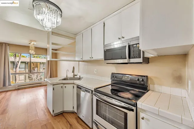 a kitchen with stainless steel appliances a stove a sink and a microwave