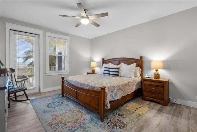 a bedroom with a large bed a chandelier and windows