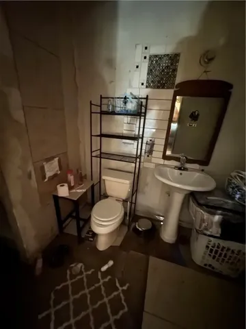 a bathroom with a toilet and a mirror
