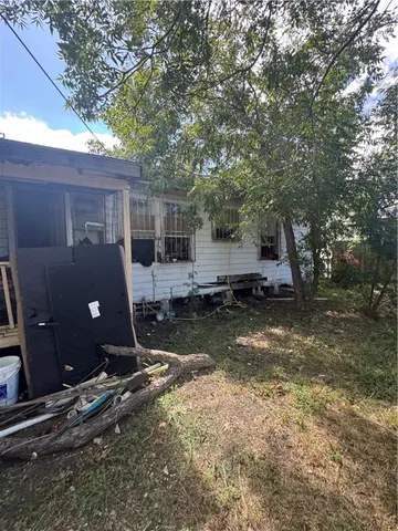 a view of backyard with large trees and wooden fence