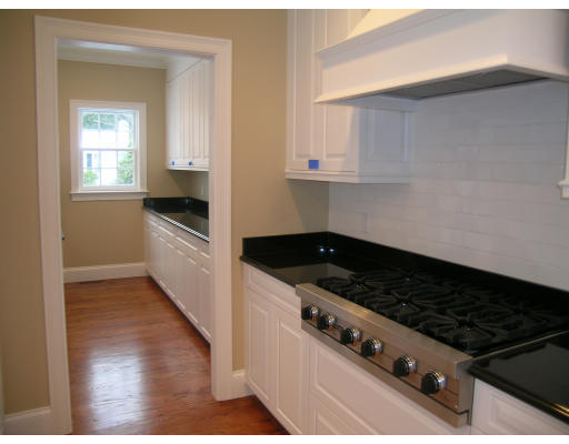 183 Middlesex Road Brookline, MA 02467 - Photo 11 of 16 a kitchen with granite countertop a stove and a wooden cabinets