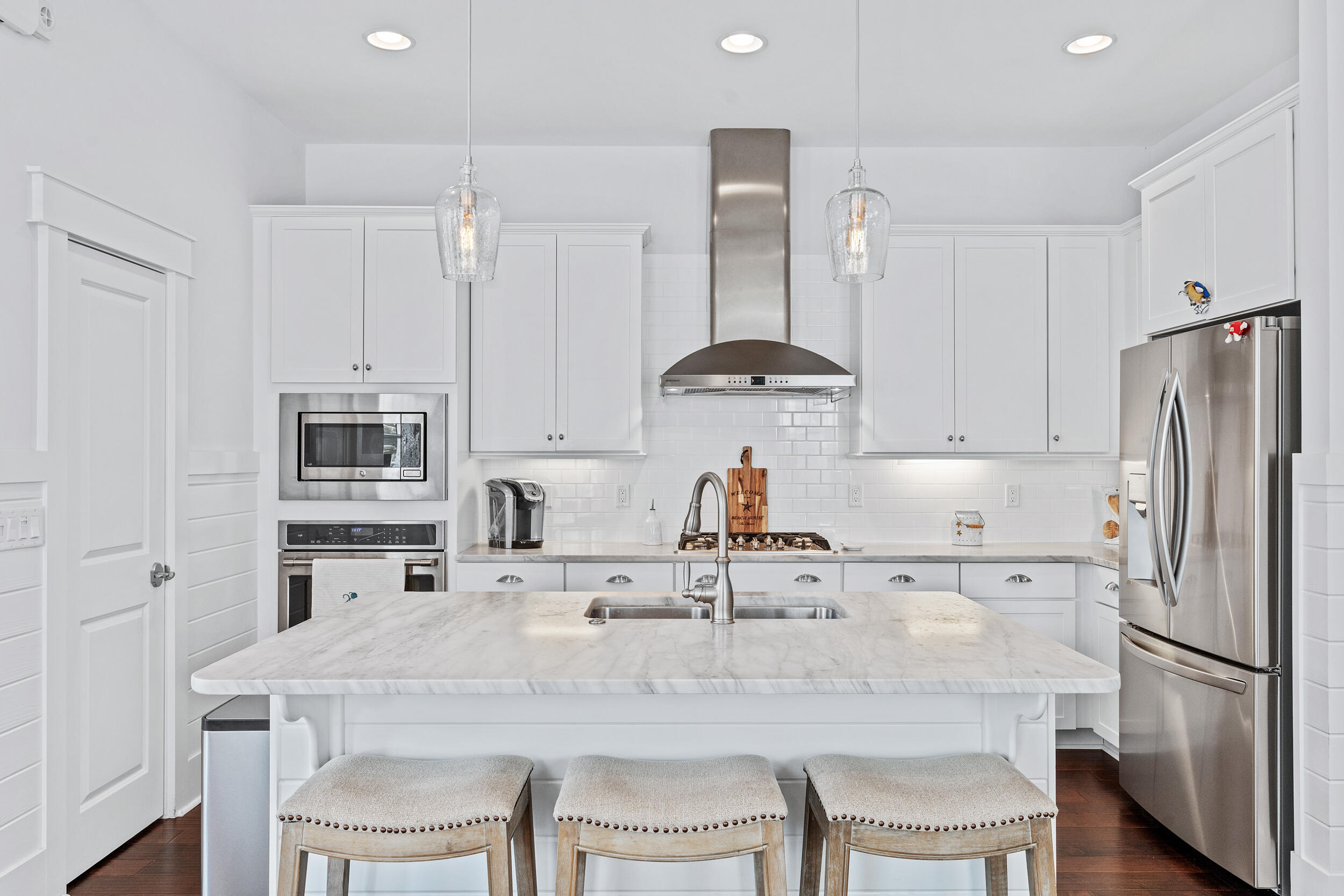282 Flatwoods Forest Loop Santa Rosa Beach, FL 32459 - Photo 10 of 52 a kitchen with stainless steel appliances a sink a stove a refrigerator with white cabinets and wooden floor