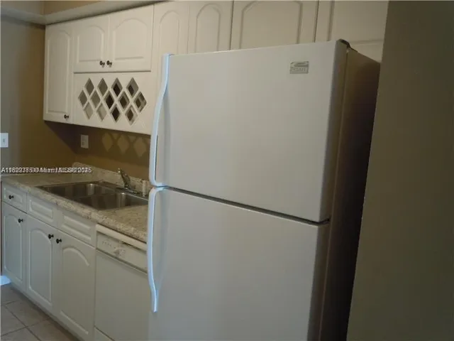 a white refrigerator freezer sitting inside of a kitchen