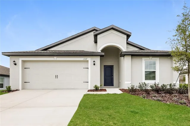 a front view of a house with a yard and garage
