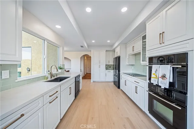 a large kitchen with stainless steel appliances granite countertop a lot of counter space and wooden floors