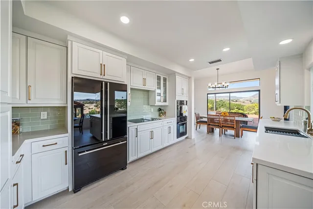 a kitchen with stainless steel appliances a refrigerator a stove and white cabinets