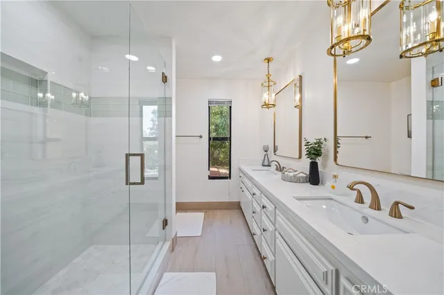 a bathroom with double vanity and a shower