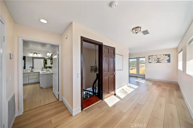 a view of a hallway view with wooden floor and a living room