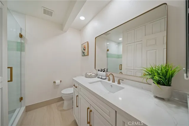 a bathroom with a sink a toilet and a mirror