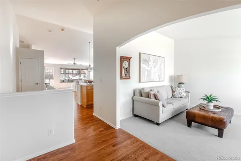 a living room with furniture and a wooden floor