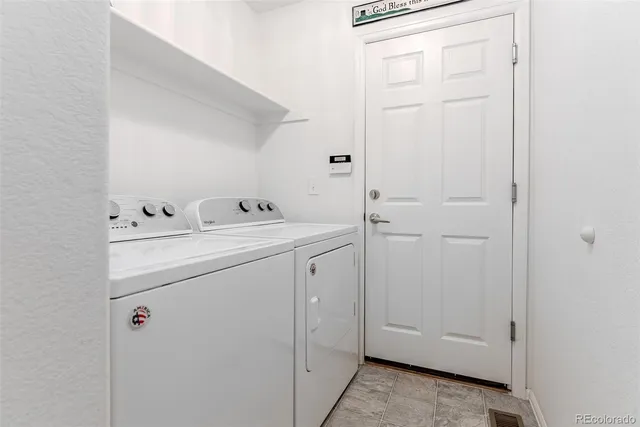 a front view of a house with a garden and trees