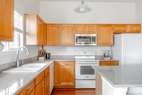 a kitchen with stainless steel appliances granite countertop a kitchen island a stove a table and chairs