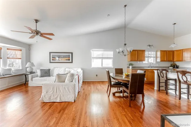 a view of a dining room with furniture a chandelier and wooden floor