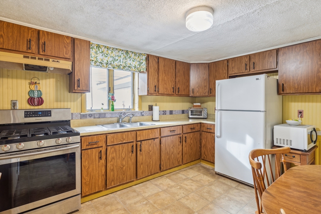 20 Hemlock Road Holbrook, MA 02343 - Photo 19 of 32 a kitchen with granite countertop a refrigerator stove top oven and sink