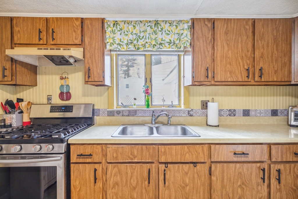 20 Hemlock Road Holbrook, MA 02343 - Photo 21 of 32 a kitchen with stainless steel appliances granite countertop a sink and a wooden cabinets