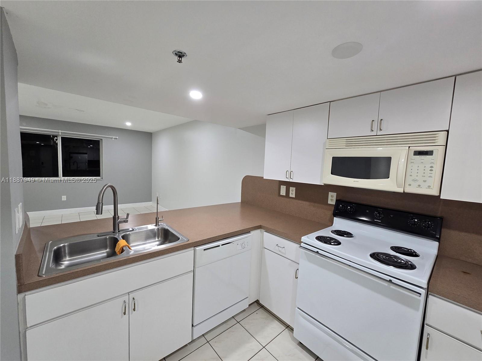 55 East 4th Street, Unit 302 Hialeah, FL 33010 - Photo 11 of 15 a kitchen with appliances a sink and cabinets