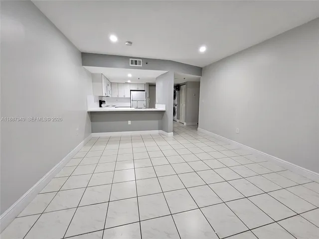 a large white kitchen with a sink and cabinets