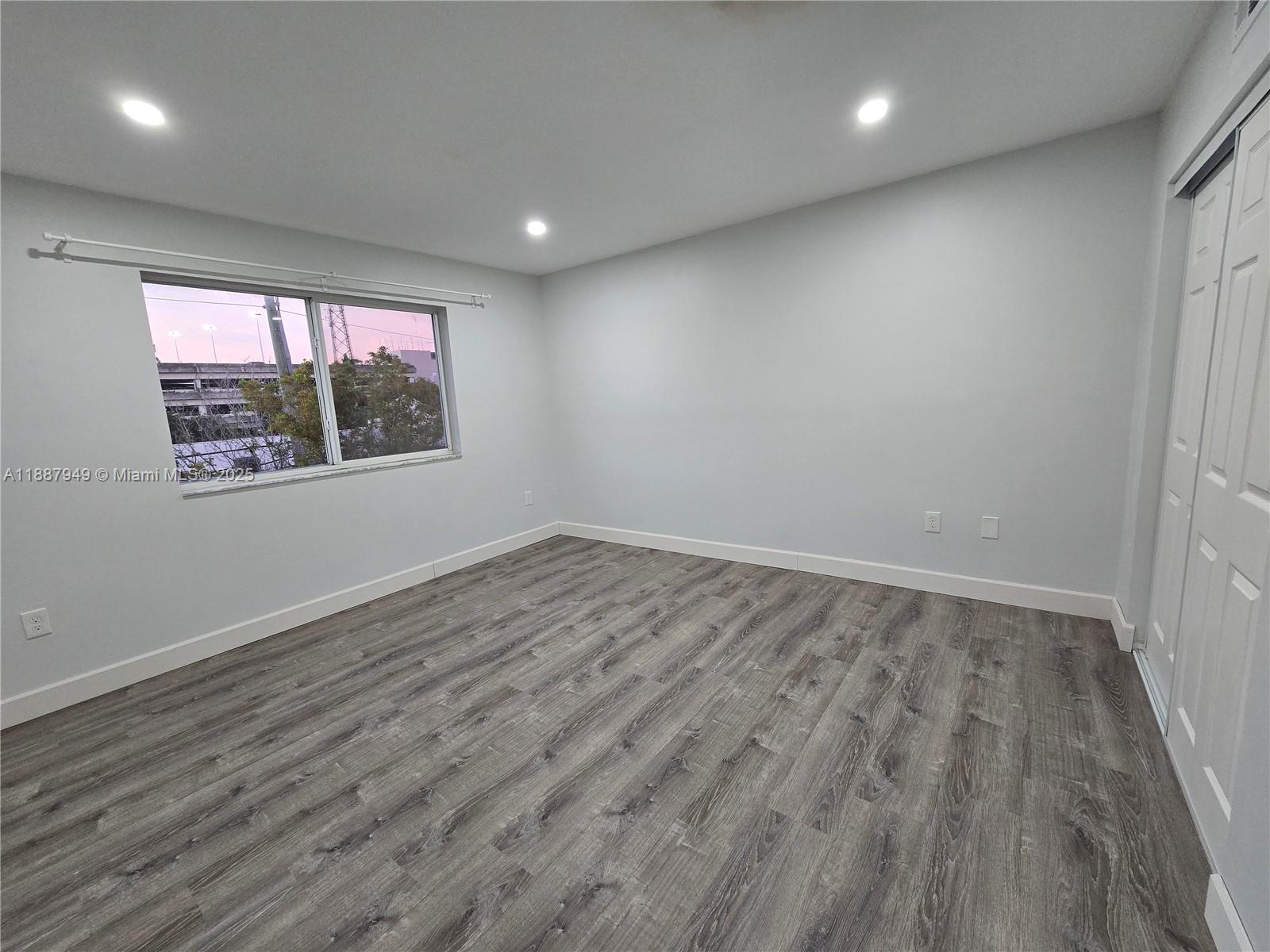 55 East 4th Street, Unit 302 Hialeah, FL 33010 - Photo 15 of 15 an empty room with wooden floor and windows