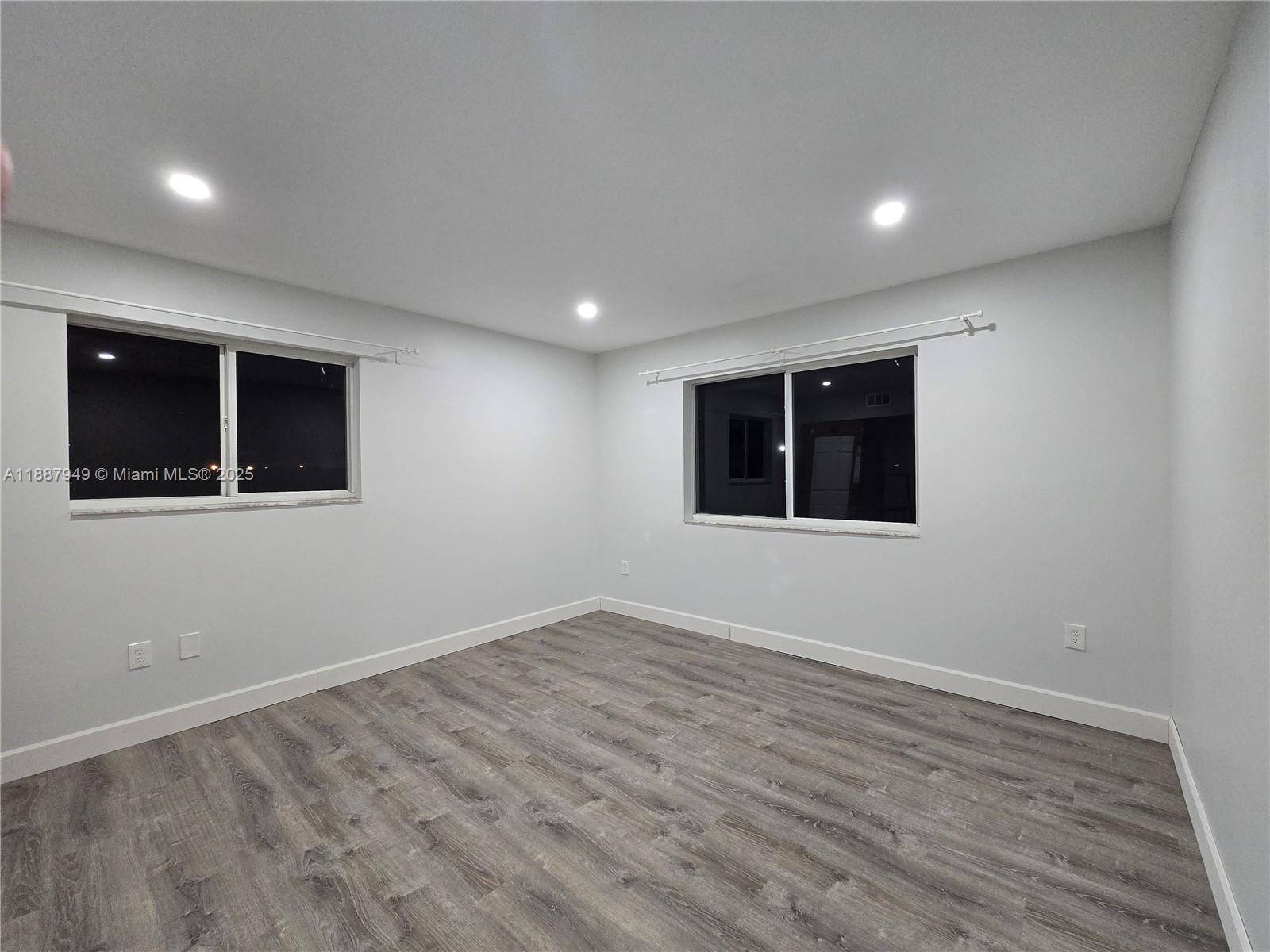 55 East 4th Street, Unit 302 Hialeah, FL 33010 - Photo 7 of 15 a view of an empty room with wooden floor and windows