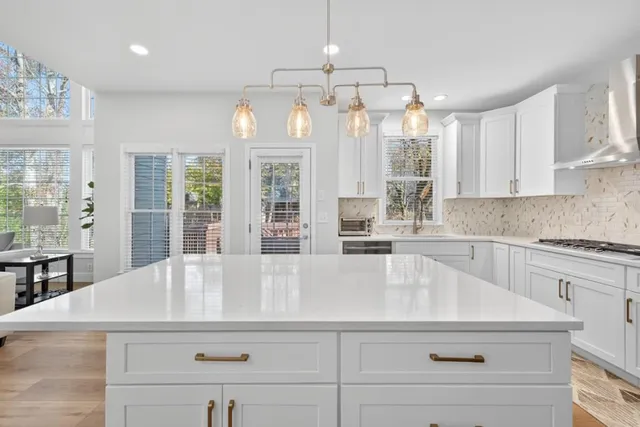 a kitchen with a sink chandelier and white cabinets