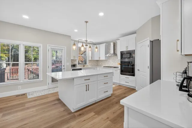 a large kitchen with kitchen island a sink stainless steel appliances and cabinets