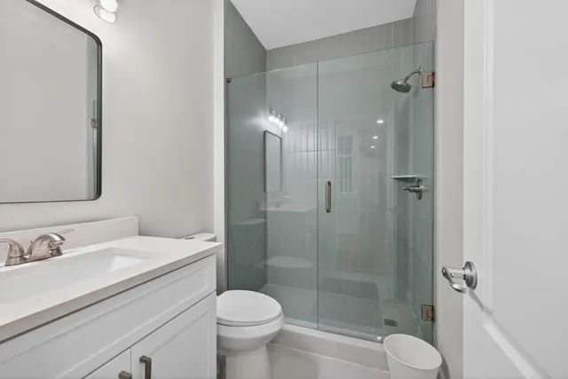 a bathroom with a sink toilet a mirror and shower