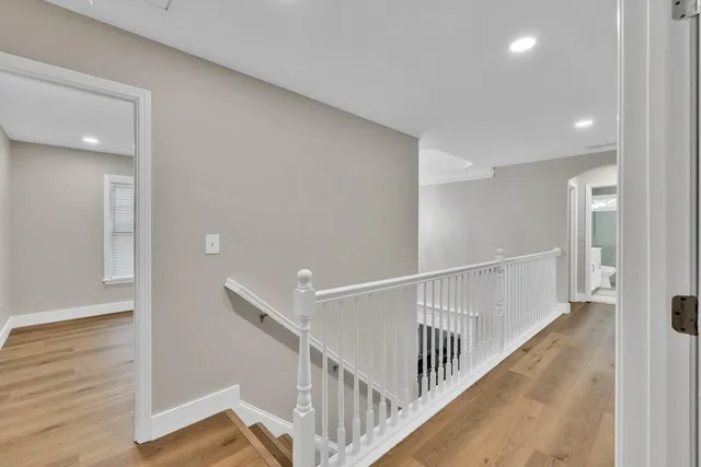 a view of a hallway with an entryway and wooden floor