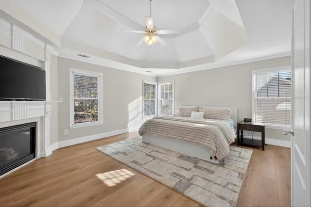 a bedroom with a large bed a flat tv screen and a fireplace