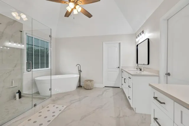 a spacious bathroom with a double vanity sink mirror and bathtub