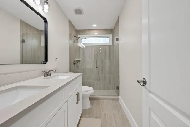 a spacious bedroom with a large bed a flat tv screen and a fireplace