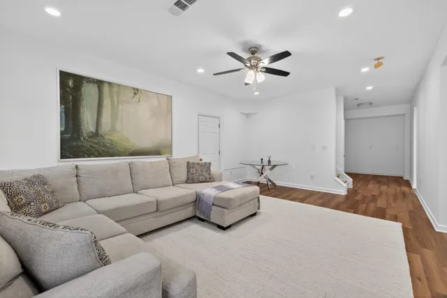 a view of empty room with wooden floor and ceiling fan