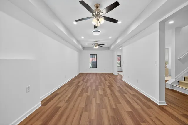 a view of a room with wooden floor and a hallway