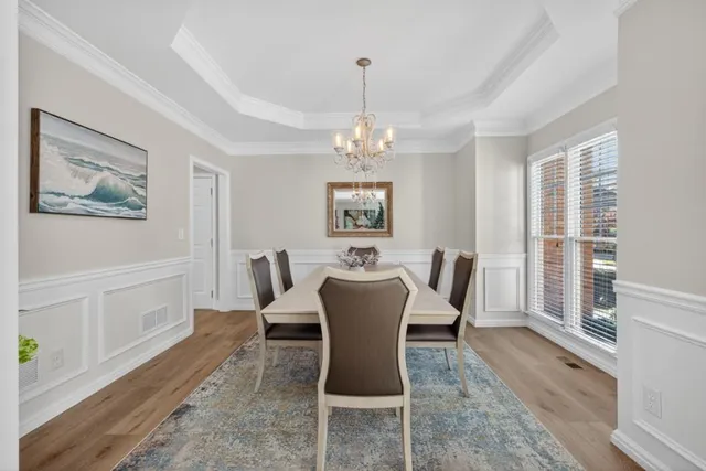 a dining room with furniture a large window and wooden floor