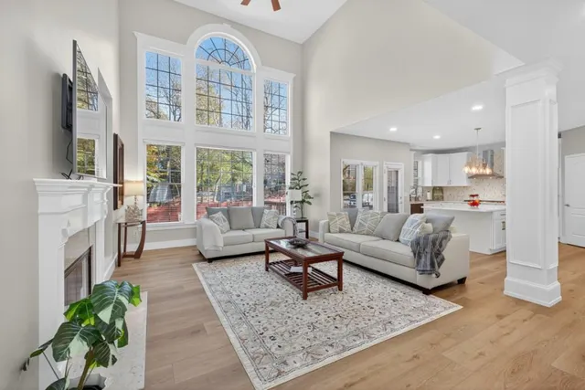 a living room with fireplace furniture and a floor to ceiling window