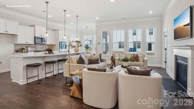 a kitchen with stainless steel appliances kitchen island granite countertop a stove and a view of living room with a flat screen tv