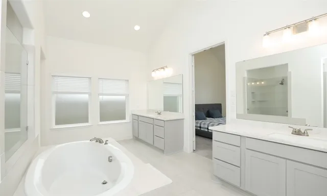 a bedroom with a bed and large windows