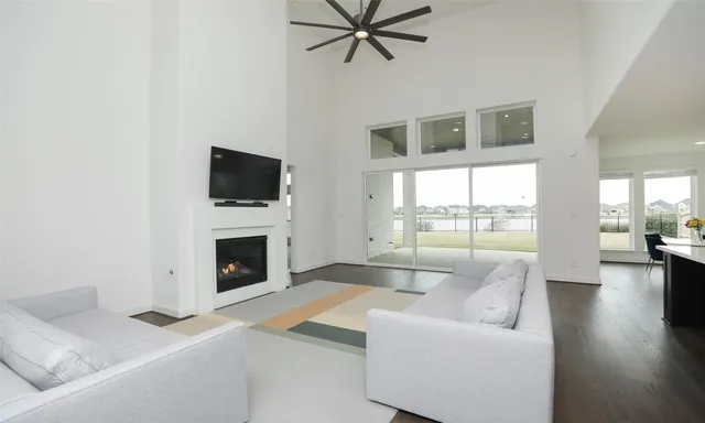 a living room with furniture a fireplace and a floor to ceiling window
