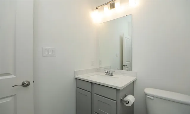 a bathroom with a sink toilet and mirror