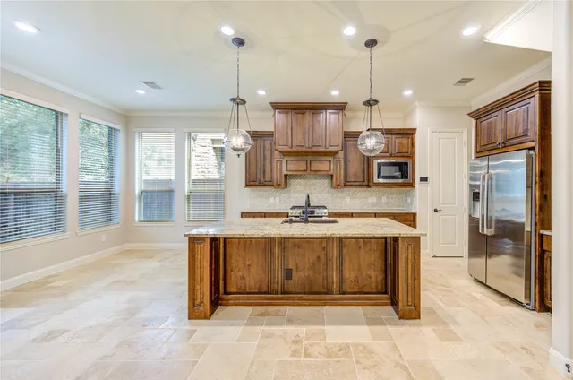 a large kitchen with stainless steel appliances kitchen island granite countertop a large kitchen island a stove a refrigerator a sink and a sink