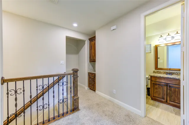 a view of a hallway to a livingroom with wooden floor and furniture