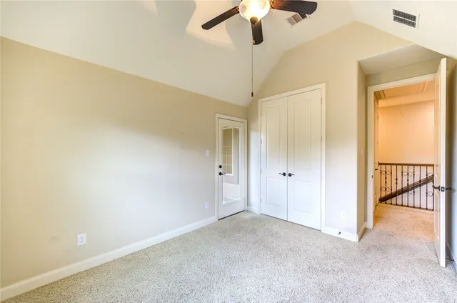 an empty room with a ceiling fan and a window