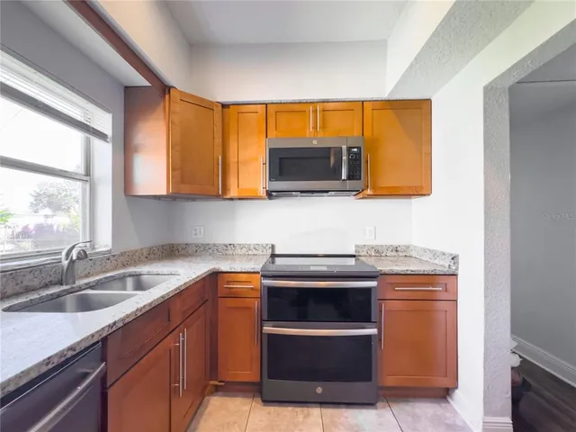 a kitchen with stainless steel appliances granite countertop a sink and a microwave