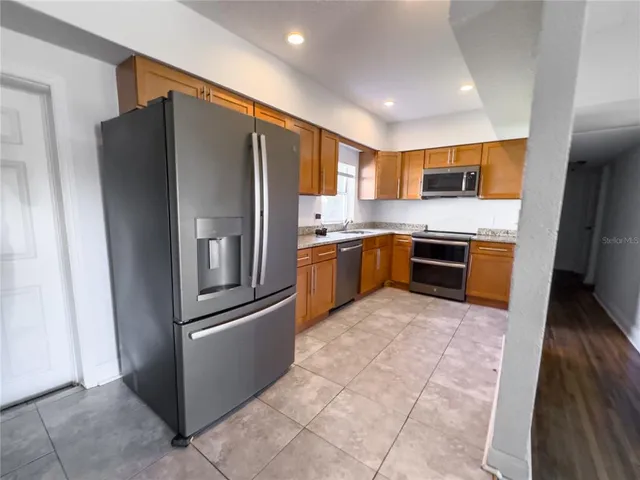 a kitchen with stainless steel appliances granite countertop a refrigerator and a sink