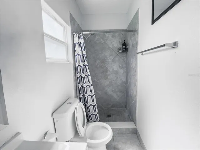 a bathroom with a toilet and a shower