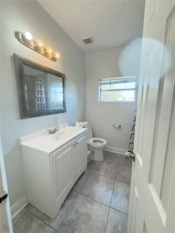 a view of bathroom with a toilet sink and mirror